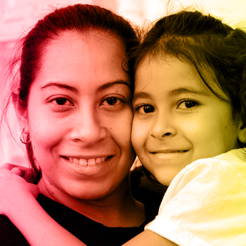 Mother and daughter hold each other and smile.