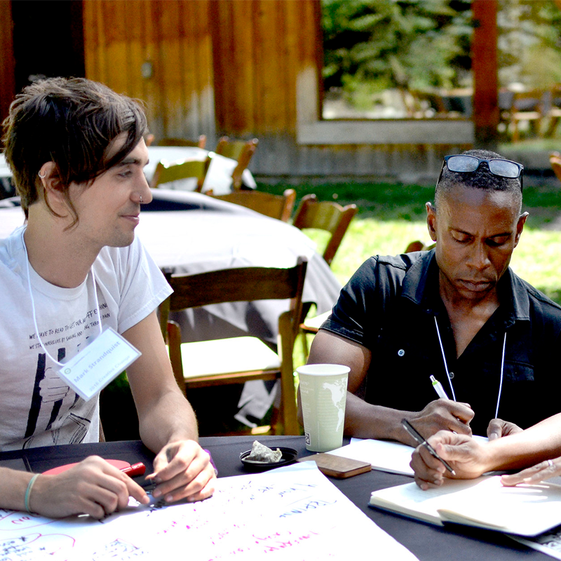 People sit at a table brainstorming ideas during the Creative Change Retreat.