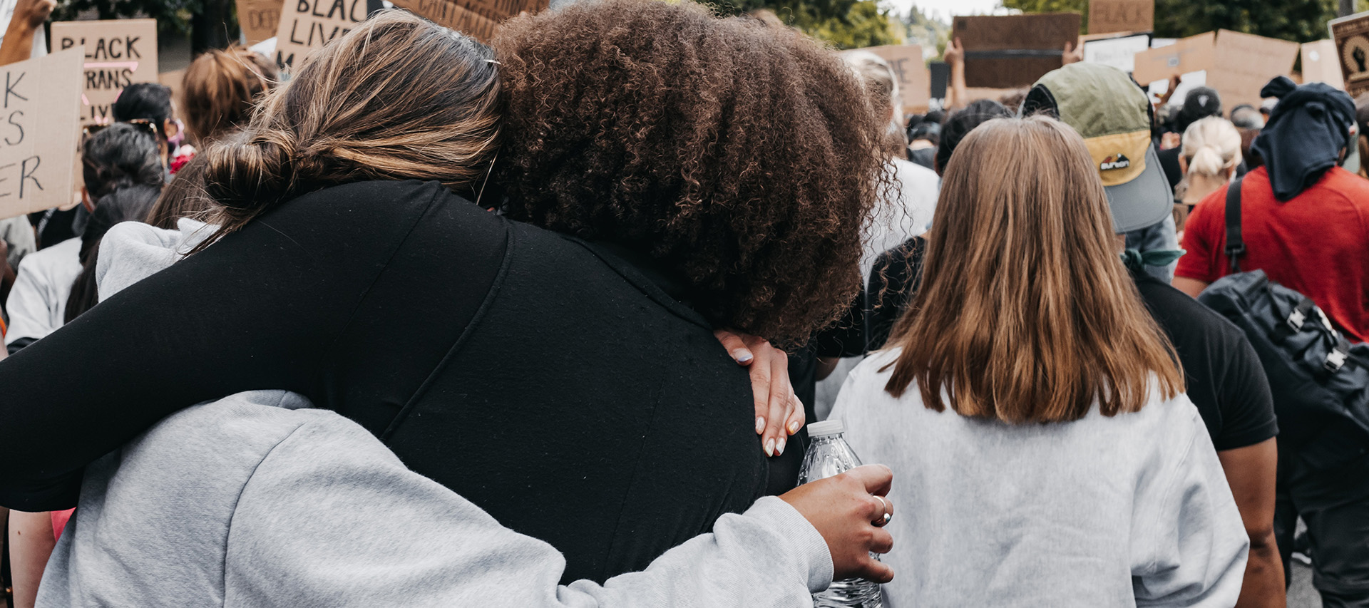 Two women embrace at a protest.