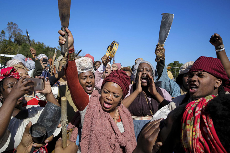 Dr. Tia Smith and others with hands up while participating in Dread Scott's Slave Rebellion Reenactment