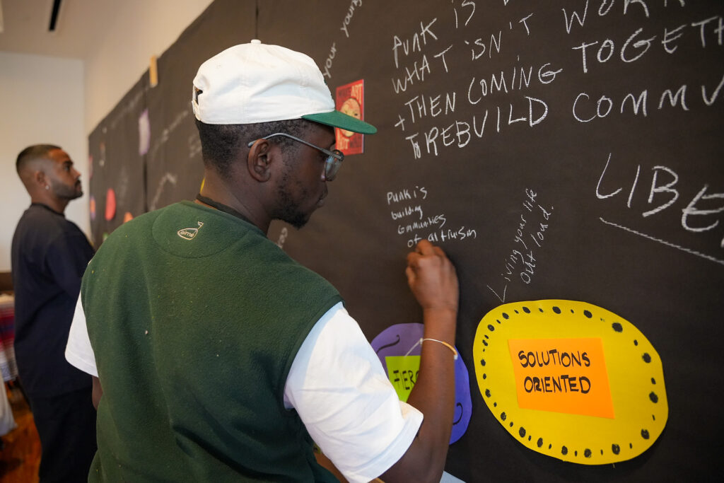 Creative Change attendees write what "punk" means to them on collage wall.